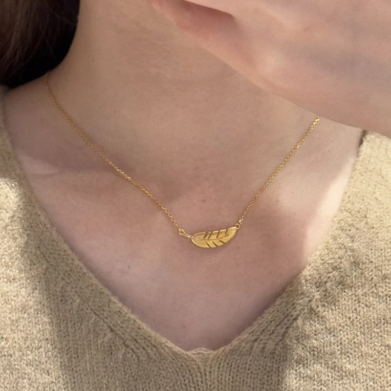 Matte gold feather necklace with jade leaf pendant and elegant clavicle chain for women