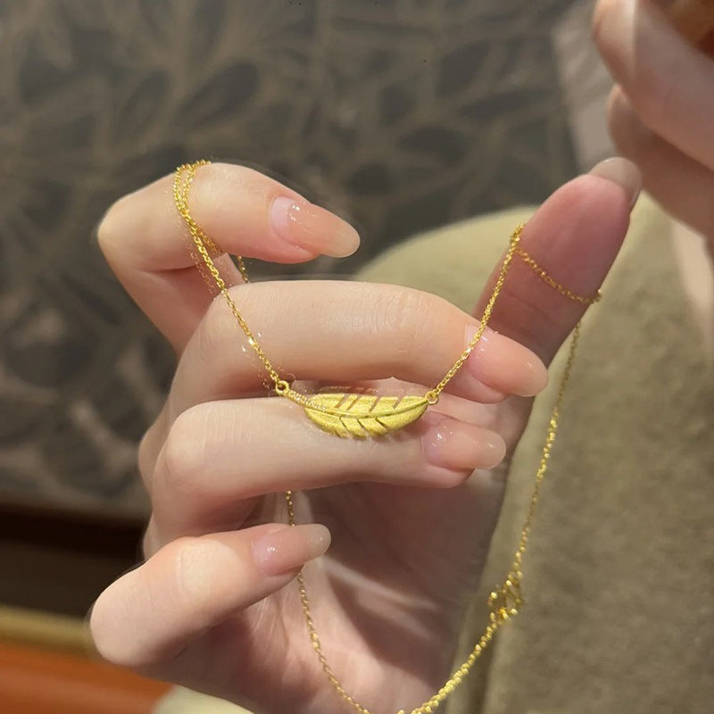 Matte gold feather necklace with jade leaf pendant and elegant clavicle chain for women