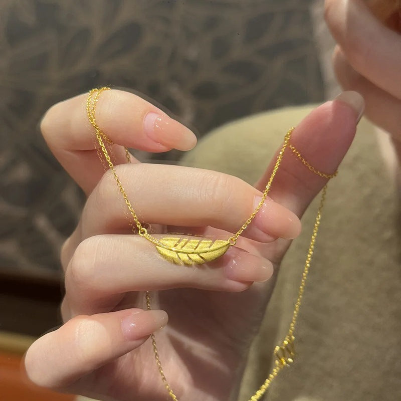 Matte gold feather necklace with jade leaf pendant and elegant clavicle chain for women