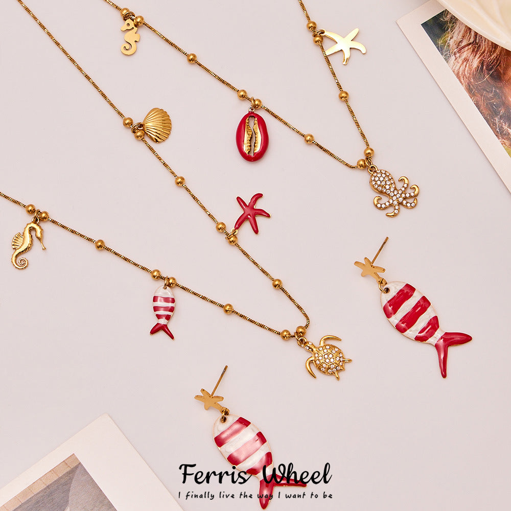 Gold plated ocean charm jewelry set featuring whimsical sea life designs including fish, turtle, and shell motifs.