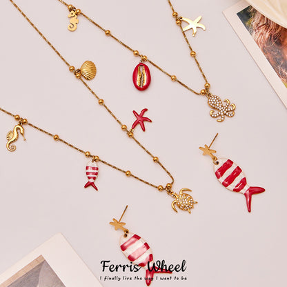 Gold plated ocean charm jewelry set featuring whimsical sea life designs including fish, turtle, and shell motifs.