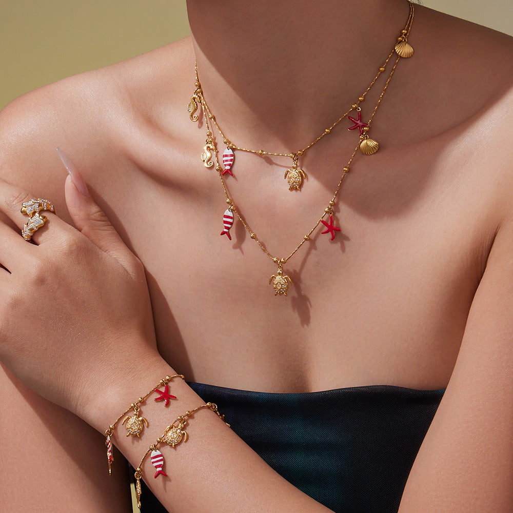 Gold Plated Ocean Charm Jewelry Set featuring a Ferris Wheel necklace and charm bracelet on a model.