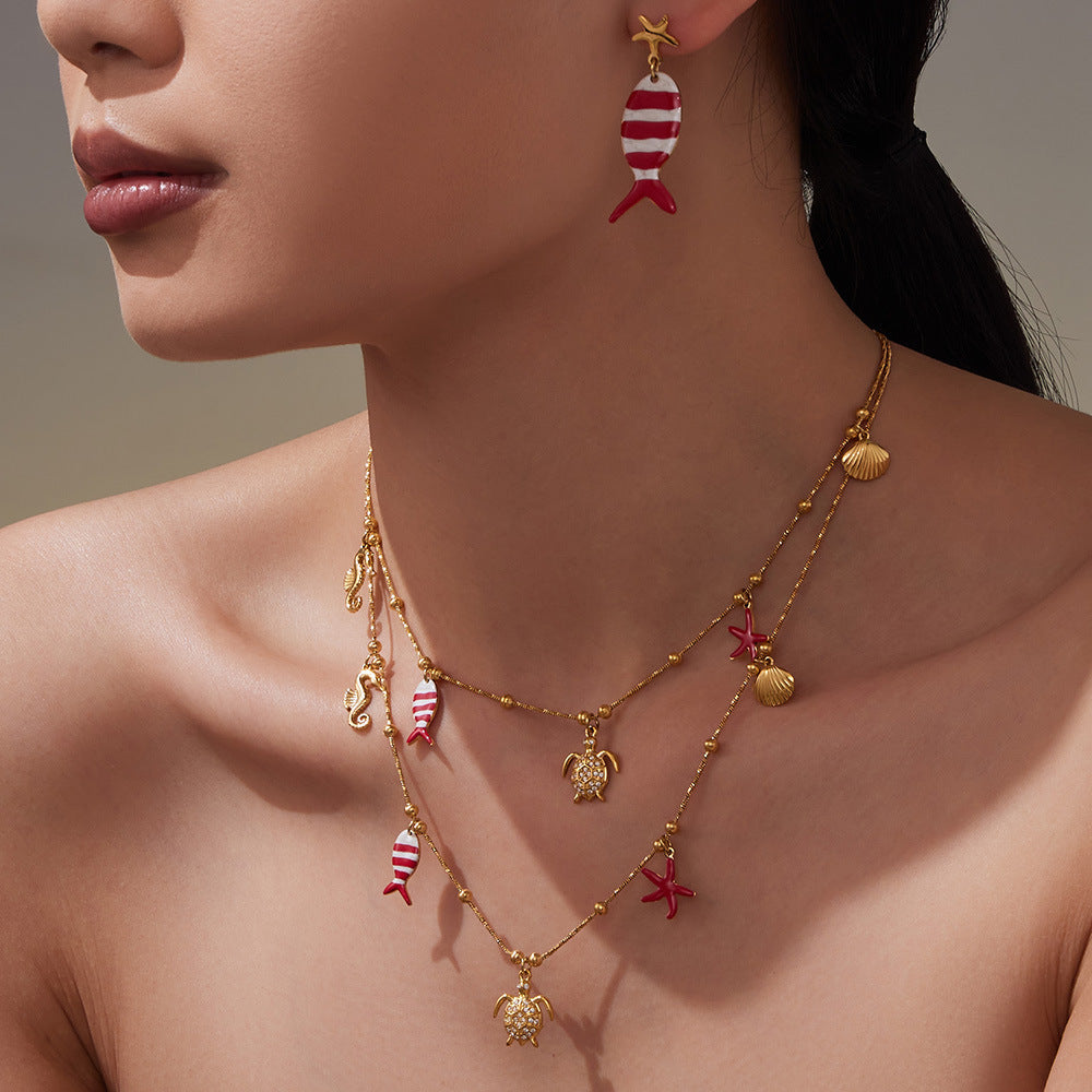 Gold plated ocean charm jewelry set featuring sea life designs including fish, turtle, and seashells.